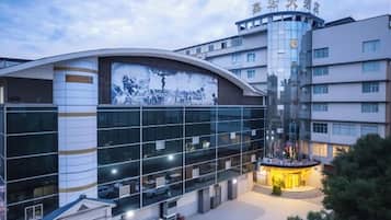 Un edificio moderno con fachada curva, amplios ventanales de vidrio y un patio central.