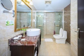 A modern bathroom with a marble vanity, a large mirror, a glass shower enclosure, and a toilet. - Xinhong Hotel (Weiyuan)