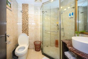 A bathroom with a glass-enclosed shower, a white toilet, and a marble countertop with a sink. - Xinhong Hotel (Weiyuan)