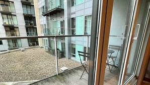 Un balcón con vista a un edificio moderno de varios pisos y balcones.