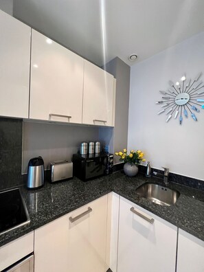 Departamento, varias camas | Cocina privada | Refrigerador, microondas, horno y parrilla de estufa 