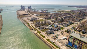 An aerial view of a coastal town with a marina, industrial buildings, and residential areas. - Beautiful newly renovated home w/ canal view (Port Colborne)