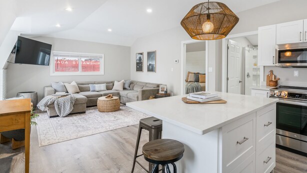 A modern kitchen with white cabinetry, a central island, and a built-in oven. - Beautiful newly renovated home w/ canal view (Port Colborne)