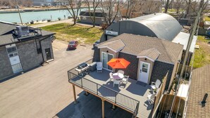 A residential building with a covered patio, a barbecue grill, and a view of a lake. - Beautiful newly renovated home w/ canal view (Port Colborne)
