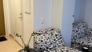 A room with a patterned sofa, a potted plant, and a door. - Casa South Studio in the Center of Stockholms Soho (Stockholm)