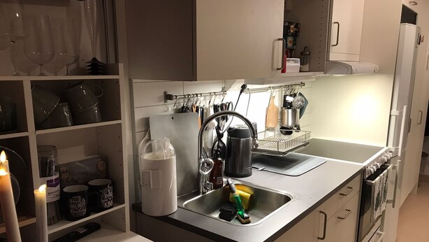 A modern kitchen with white cabinets, a stainless steel sink, and a kettle. - Casa South Studio in the Center of Stockholms Soho (Stockholm)
