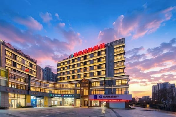 Un hotel de varios pisos con una entrada destacada y señalización.