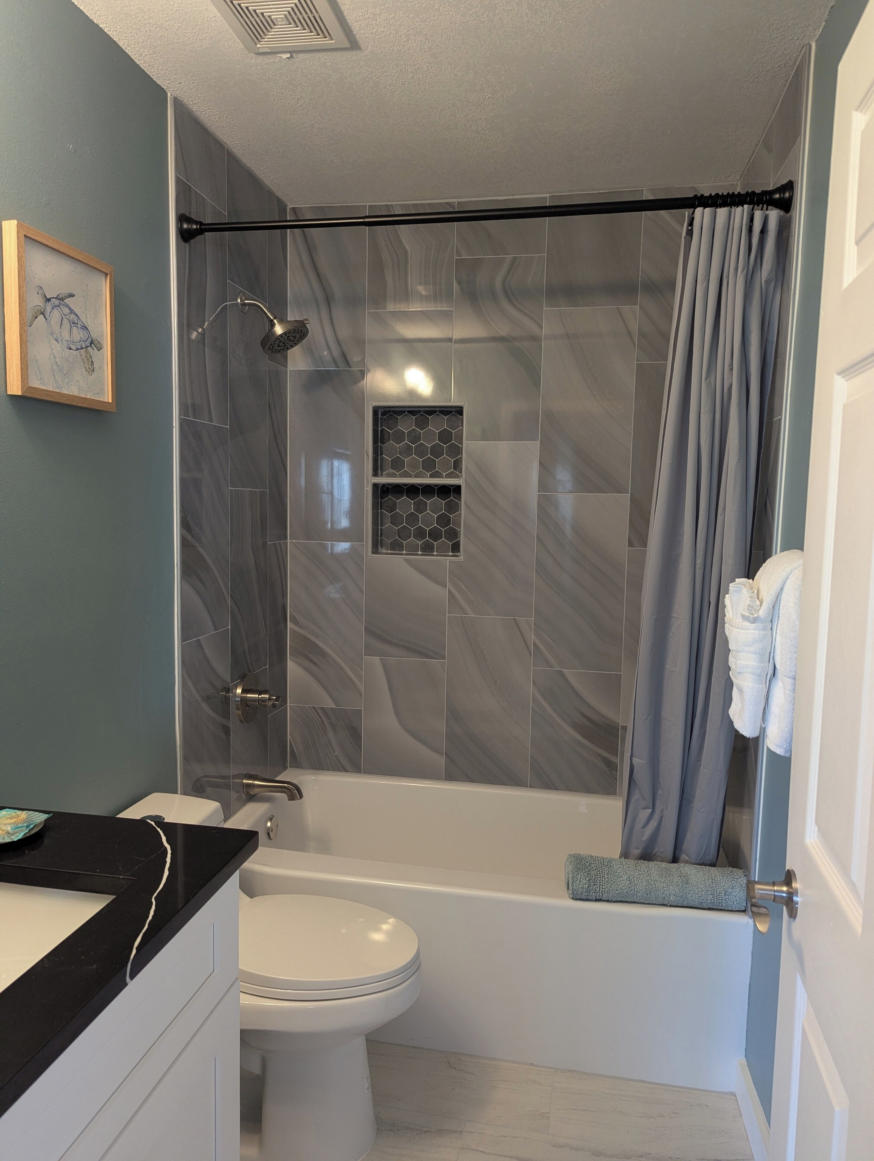 Un baño moderno con ducha, inodoro y lavamanos.