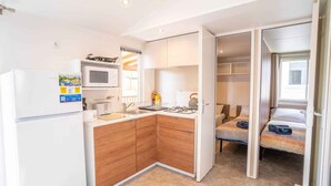 A compact kitchen with a microwave, toaster, and a refrigerator.