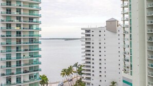 Un immeuble de grande hauteur doté de nombreux balcons donnant sur une étendue d’eau.