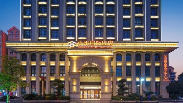 A multi-story hotel with a prominent entrance, large windows, and illuminated signage.