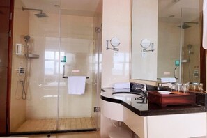 A modern bathroom with a glass-enclosed shower, a large mirror, and a vanity with a black countertop. - ZHONGZHOU INTERNATIONAL HOTEL (Xinyang)