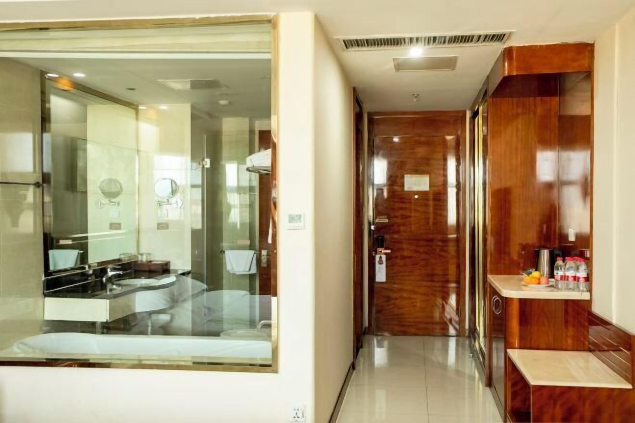 Un bagno moderno con doccia vetro, un mobile lavabo con specchio e un armadietto in legno con articoli da toilette.