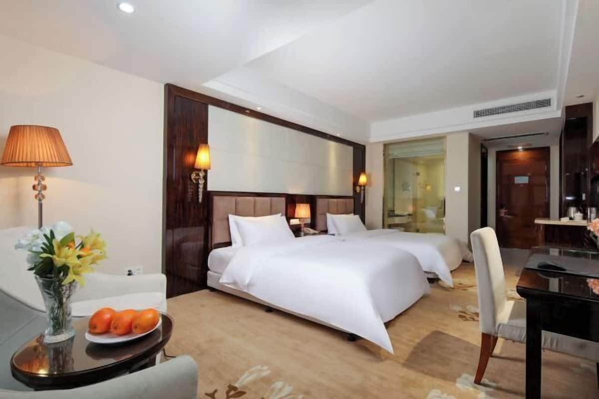 Ein Hotelzimmer mit Bett, Nachttischen, Schreibtisch und Stuhl.