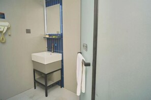 A bathroom with a white sink, blue-tiled wall, and a towel hanging on a door handle. - 7Days Inn Chain Hotel (Chongqing Bund International) (Chongqing)