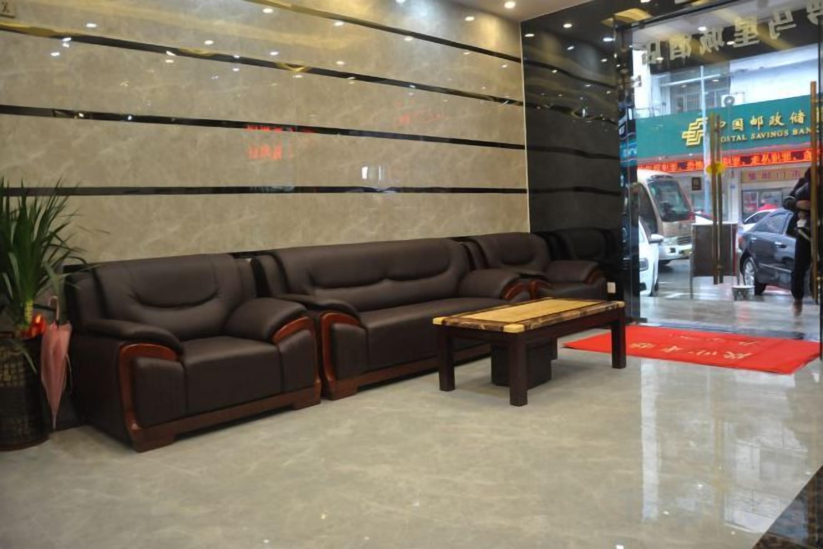 A lobby with a sofa, a coffee table, and a reception desk.