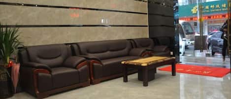 A lobby with a sofa, a coffee table, and a reception desk.