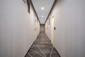 A hotel hallway with doors on both sides, a patterned carpet, and a ceiling with recessed lighting. - Rome Star City Shenzhen (Buji Old Street) (Shenzhen)