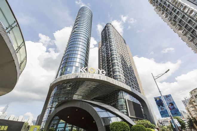 A modern building with a curved facade and two prominent towers.