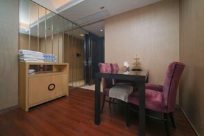 A modern room with a wooden cabinet, a dining table with two purple chairs, and a glass partition. - Senmei International Apartment Hotel (Shenzhen Binhe Shidai) (Shenzhen)