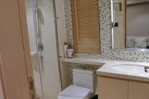 Un baño con ducha, inodoro y lavamanos.
