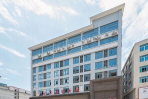A multi-story building with a modern architectural design, featuring a series of windows and a flat roof. - Yihao Hotel (Xianyou)