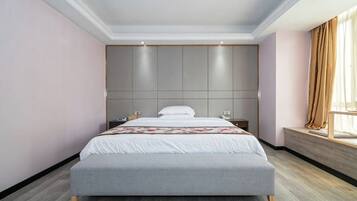 Una habitación de hotel moderna con una cama grande, un cabecero con iluminación integrada, una mesita de noche y un ventanal con cortinas.