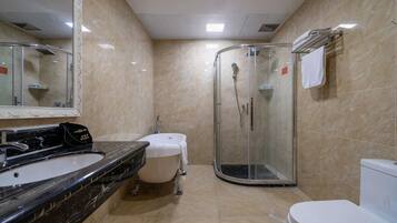 Un baño con lavamanos de mármol, inodoro, ducha y espejo.