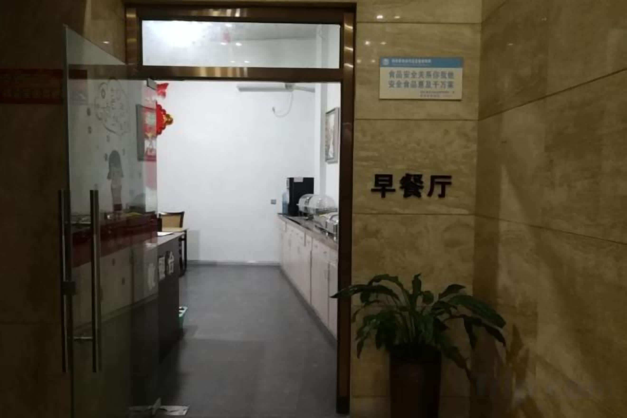 A corridor leading to a reception area with a sign indicating a breakfast area.