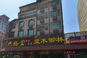 Un edificio de varios pisos con planta baja comercial, que muestra señalización de un restaurante y un negocio.