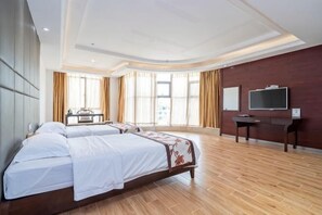 A hotel room with a large bed, a desk, a TV, and a window with curtains. - Yihao Hotel (Xianyou)