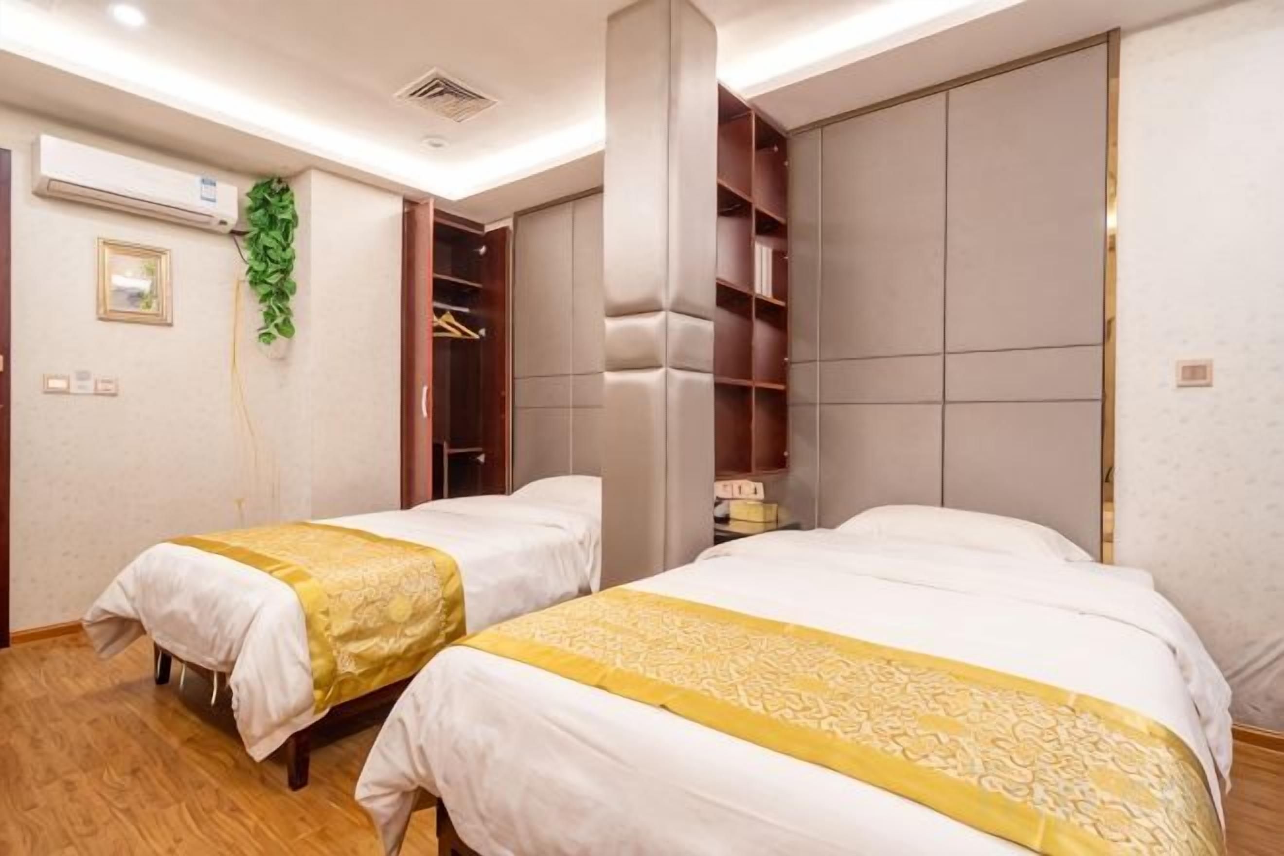 A hotel room with two beds, a wardrobe, and a mirror.