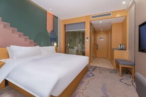 A hotel room with a large bed, a desk, a TV, and a staircase. - Fragrans Hotel (Suzhou)