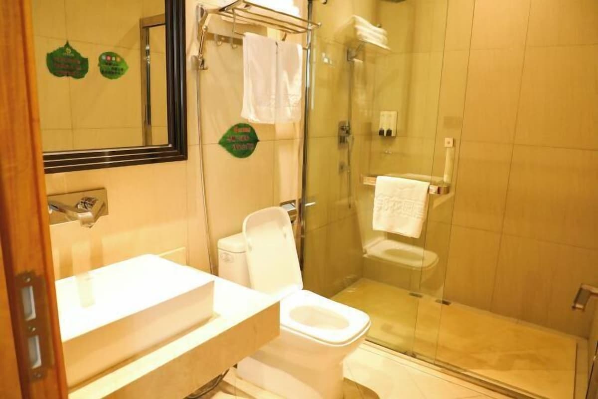 Une salle de bain équipée de toilettes, d’un lavabo et d’une douche à parois en verre.