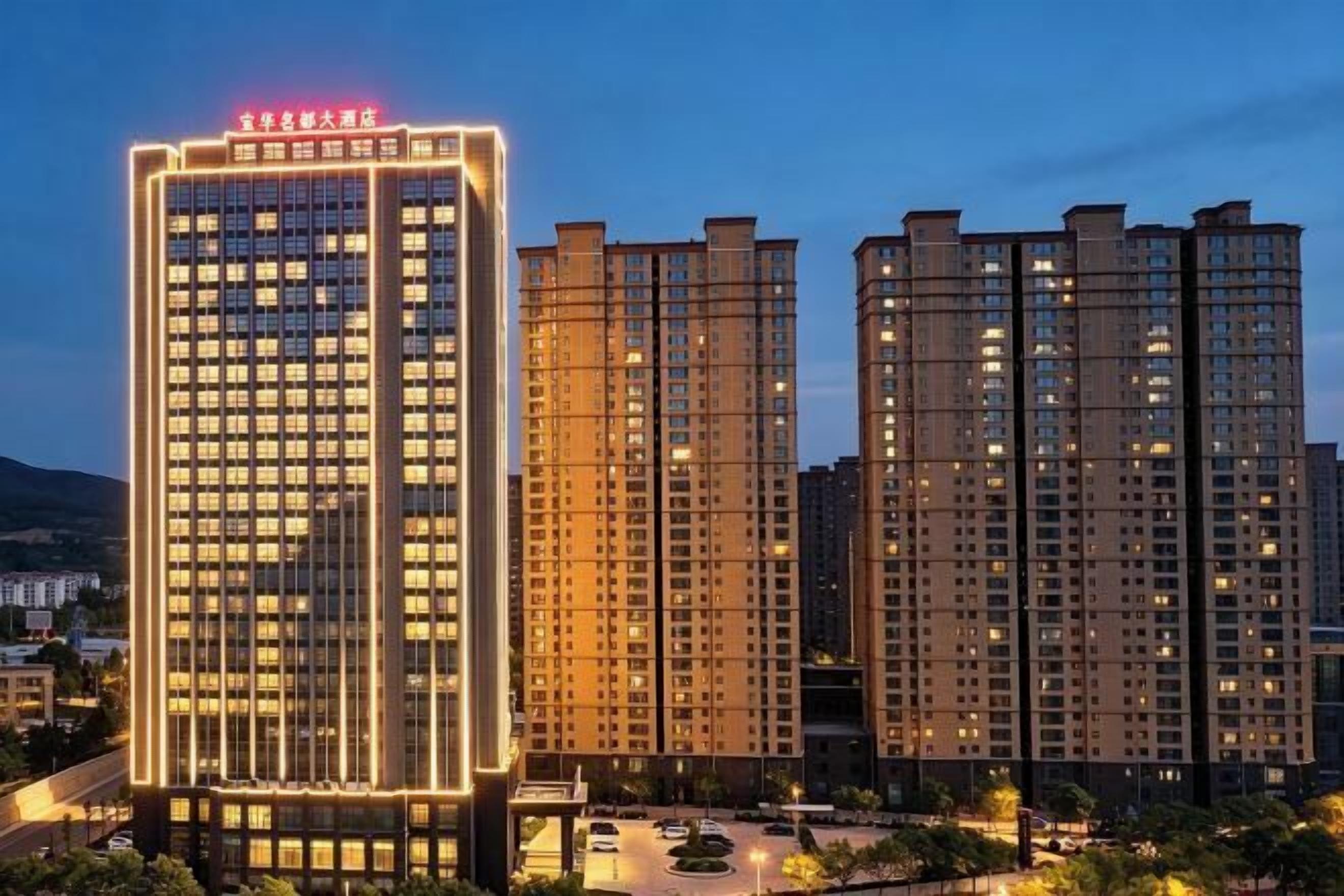 A high-rise building with illuminated windows and a clear sky.