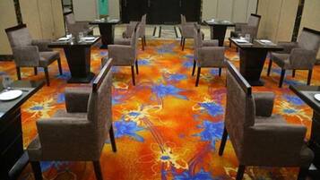 A conference room with a floral carpet, tables, and chairs arranged for meetings.