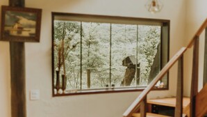 Ein Essbereich mit einem Tisch für zwei Personen, einer gepolsterten Bank und einer Treppe, die zu einer oberen Ebene führt.