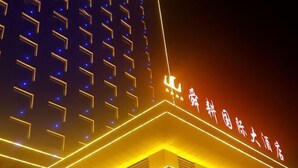 Un edificio con señalización iluminada y patrones geométricos en su fachada.