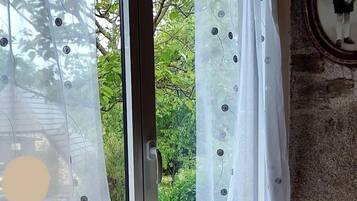 Une pièce avec une grande fenêtre, un radiateur en dessous et un miroir au mur.