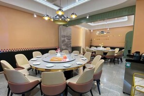 A conference room with a round table, multiple chairs, and a buffet area. - Yuxiangyuan Hotel (Gongliu)