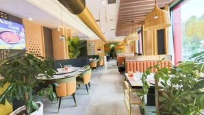 Un restaurant au décor moderne, avec un long comptoir, des banquettes et des plantes en pot.
