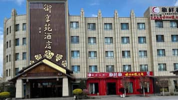A multi-story hotel with a prominent vertical sign on the facade.
