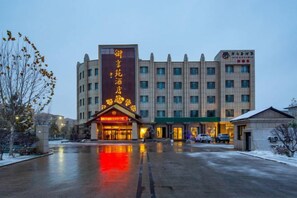 A hotel with a prominent entrance, multiple floors, and a parking area. - Yuxiangyuan Hotel (Gongliu)