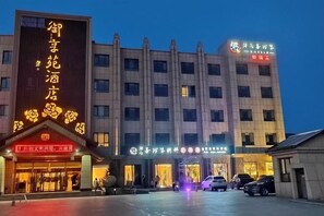 A hotel with a prominent entrance, multiple floors, and illuminated signage.
