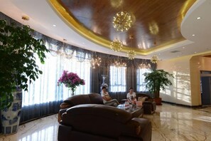 A spacious lobby with a large seating area, a grand chandelier, and a large potted plant. - Yuxiangyuan Hotel (Gongliu)