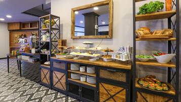 A buffet setup with various food items and a mirror on the wall.