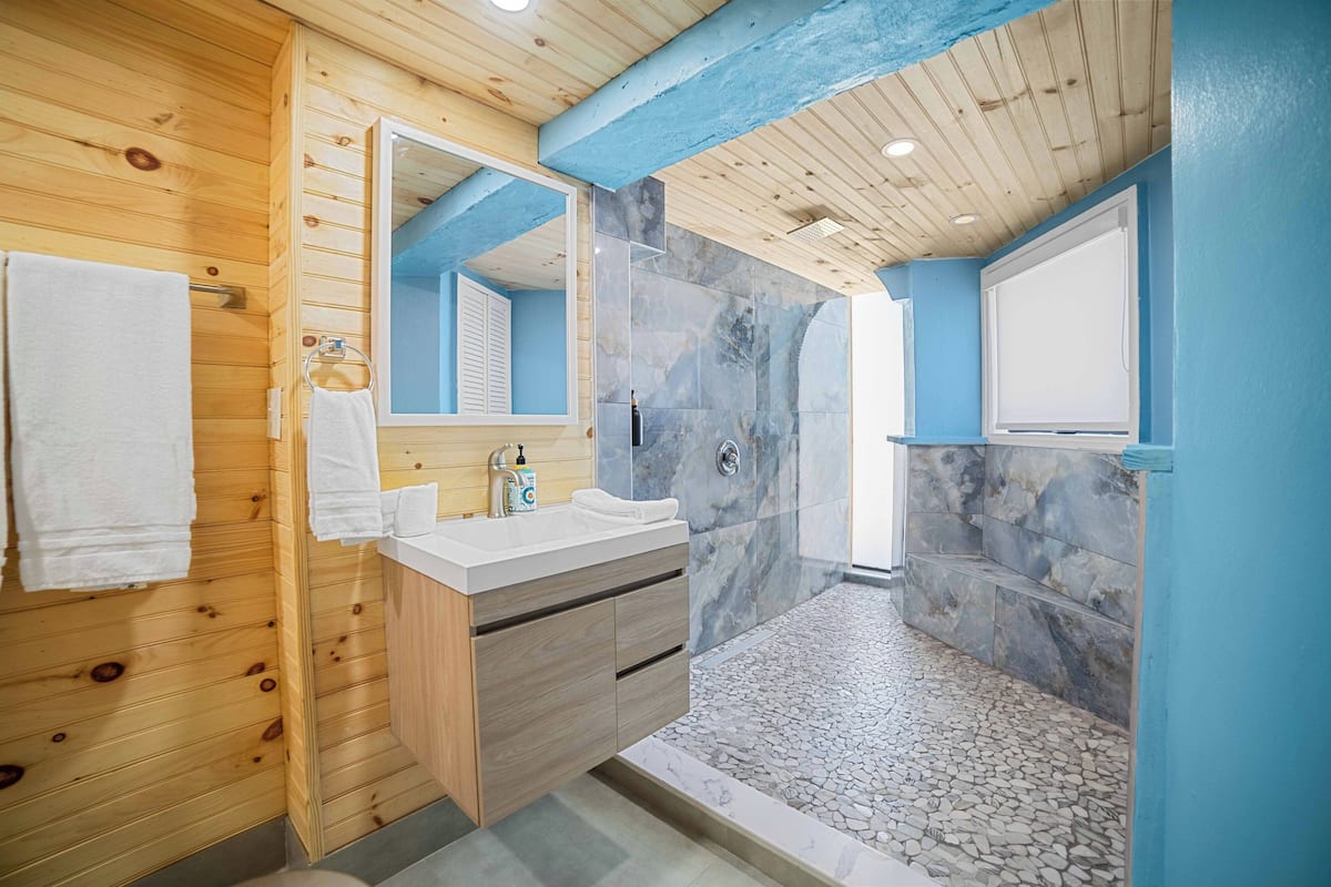 Ocean View Room | Badkamer | Een douche, een regendouche, handdoeken