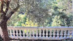 A stone bench with a balustrade in a garden setting.