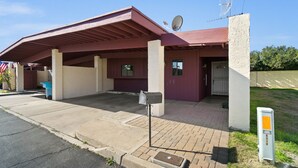 Un bâtiment avec un toit rouge, une antenne parabolique et une boîte aux lettres.