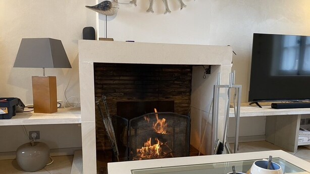 Ein Wohnzimmer mit Kamin, Flachbildfernseher und Couchtisch mit Tassen.